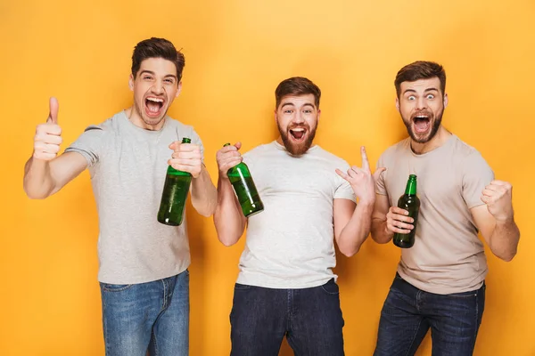 Three Young Men Drinking Beer Celebrating Isolated Yellow Background — Stock Photo, Image