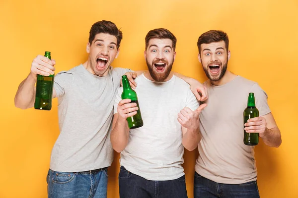 Tres Jóvenes Felices Sosteniendo Cerveza Celebrando Aislados Sobre Fondo Amarillo — Foto de Stock