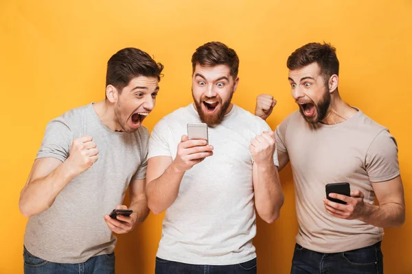 Tre Unga Glada Män Tittar Mobiltelefon Och Firar Isolerade Över — Stockfoto
