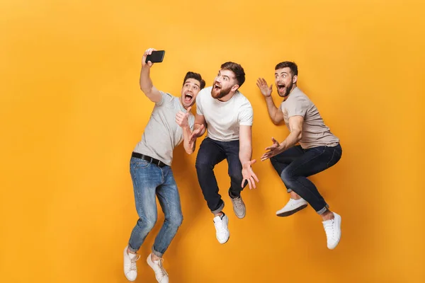 Três Jovens Homens Sorridentes Tomando Uma Selfie Juntos Enquanto Saltam — Fotografia de Stock