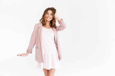 Görüntü izole kamera seyir beyaz duvar arka plan üzerinde duran şaşırtıcı genç güzel kadın.