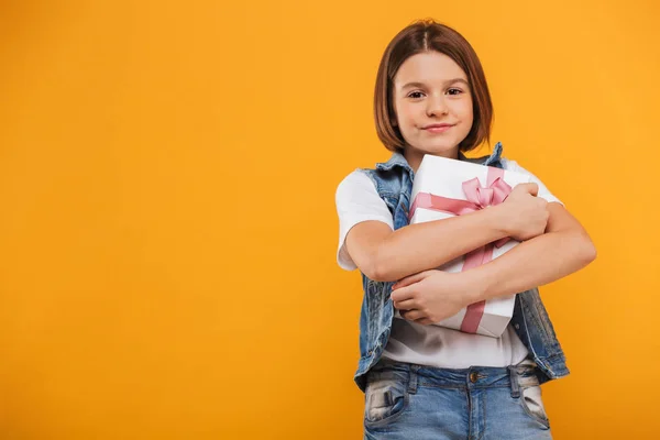 Portret Van Een Tevreden Weinig Schoolmeisje Bedrijf Geschenkdoos Gele Achtergrond — Stockfoto