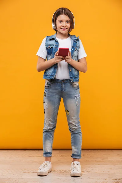 Volledige Lengte Portret Van Een Gelukkig Weinig Schoolmeisje Luisteren Naar — Stockfoto