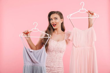 Alışveriş izole pembe arka plan üzerinde iken basılı tutup seçimi 20s askı elbise Alışverişkoliğin kadın fotoğrafı