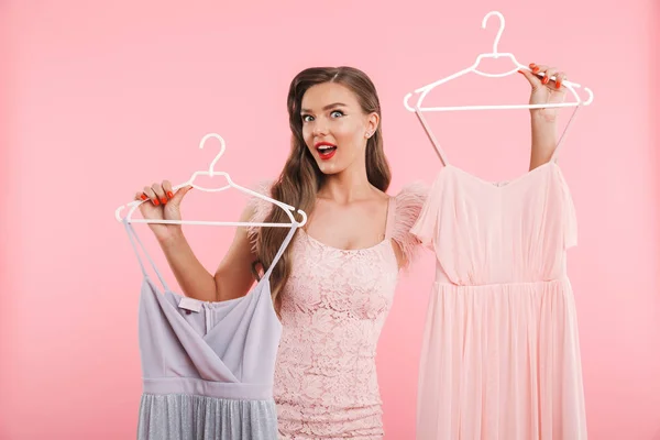 Photo Shopaholic Woman 20S Holding Choosing Dresses Hangers While Shopping — Stock Photo, Image