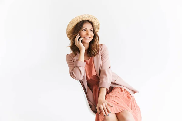 白い壁の背景見ると携帯電話で話している脇分離に座っていた幸せな美しい女性のイメージ — ストック写真