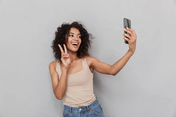 Portrait Smiling Young African Woman Taking Selfie Mobile Phone Gray — Stock Photo, Image