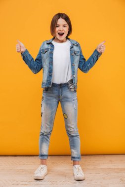 Tam uzunlukta jest Yaşasın sarı arka plan üzerinde gösterilen bir heyecan küçük kız öğrenci portresi