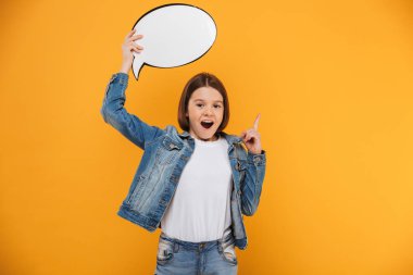Boş konuşma balonu sarı arka plan üzerinde tutan bir heyecan küçük kız öğrenci portresi