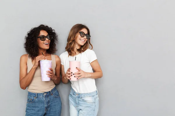 Retrato Duas Mulheres Jovens Sorridentes Óculos Segurando Copos Plástico Olhando — Fotografia de Stock