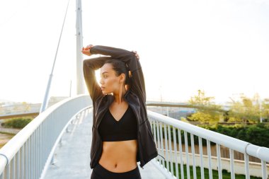 Çok güzel genç Asyalı spor kadın olun germe egzersizleri açık havada resim.