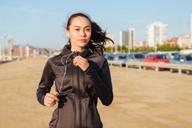 Fotoğraf inanılmaz güzel genç Asyalı açık havada dinleme müzik çalışan kadın spor.