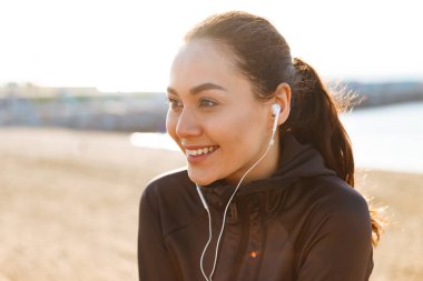 Fotoğraf neşeli Genç Asyalı bir kenara seyir açık havada dinleme müzik oturan kadın spor.