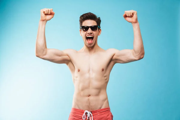 Portrait Happy Young Shirtless Man Swimming Shorts Sunglasses Celebrating Success — Stock Photo, Image