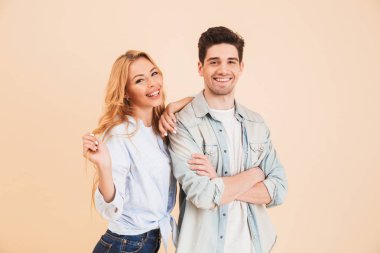 Bej renkli arka plan üzerinde beyaz gençler erkek ve kadın temel giyim birlikte mutlu gülümseme ile kamera poz portre izole