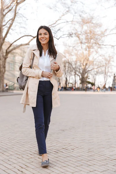 Mulher Bonita Vestida Com Casaco Outono Carregando Laptop Enquanto Caminhava — Fotografia de Stock