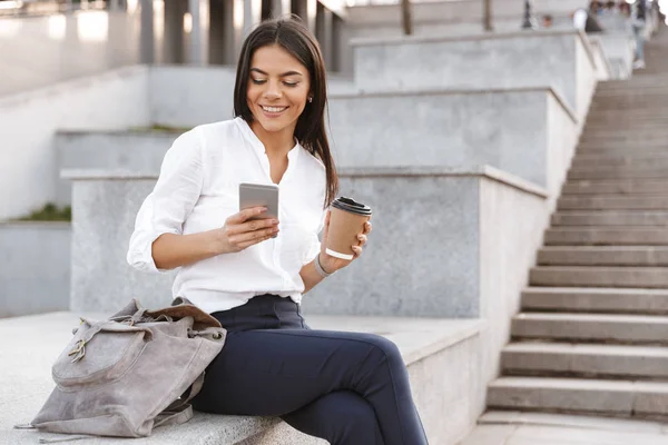 Mujer Joven Sonriente Sosteniendo Teléfono Móvil Mientras Está Sentado Una —  Fotos de Stock