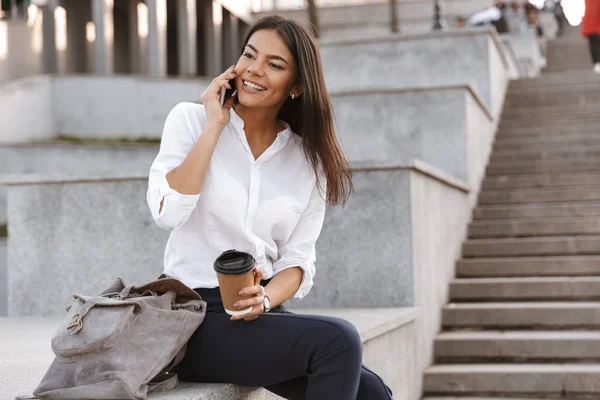 Улыбающаяся Молодая Женщина Разговаривает Мобильному Телефону Сидя Лестнице Чашкой Кофе — стоковое фото