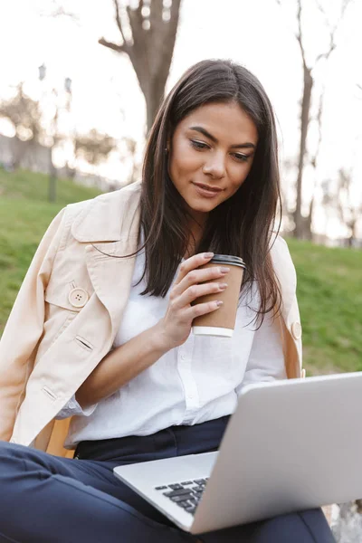 Atractiva Joven Mujer Usando Ordenador Portátil Mientras Está Sentado Banco — Foto de Stock