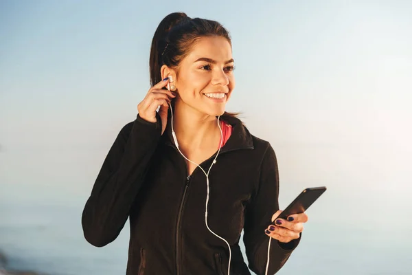 Aantrekkelijke Jonge Sportvrouw Luisteren Naar Muziek Met Oortelefoons Mobiele Telefoon — Stockfoto