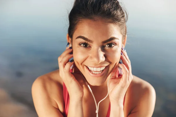 Close Van Een Lachende Sportvrouw Luisteren Naar Muziek Met Oortelefoons — Stockfoto