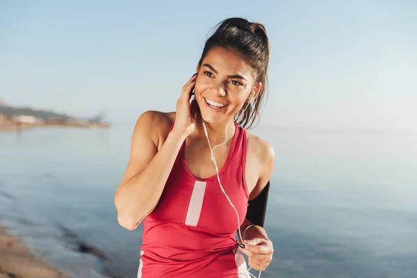 Sorrindo Esportes Mulher Ouvindo Música Por Smartphone Olhando Para Longe — Fotografia de Stock