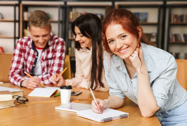 Groep Opgewonden Tieners Huiswerk Tijdens Vergadering Bibliotheek Met Mobiele Telefoon — Stockfoto