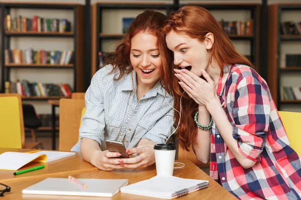 Portre Bir Iki Genç Kız Kütüphanede Otururken Cep Telefonu Arıyorum — Stok fotoğraf