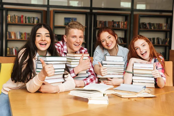 Grupo Adolescentes Alegres Sentados Mesa Biblioteca Com Grandes Pilhas Livros — Fotografia de Stock