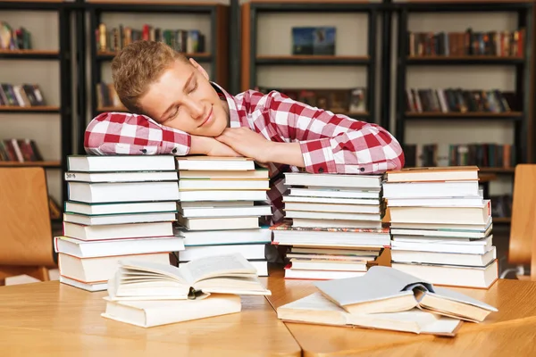 Cansado Adolescente Sentado Mesa Biblioteca Com Grandes Pilhas Livros Dormindo — Fotografia de Stock