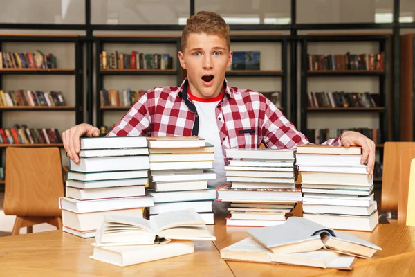 Tiener Jongen Zitten Aan Tafel Van Bibliotheek Met Grote Stapels — Stockfoto