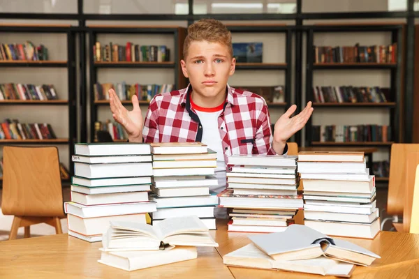Συγχέεται Εφηβικό Αγόρι Που Κάθεται Στο Τραπέζι Βιβλιοθήκη Μεγάλες Στοίβες — Φωτογραφία Αρχείου