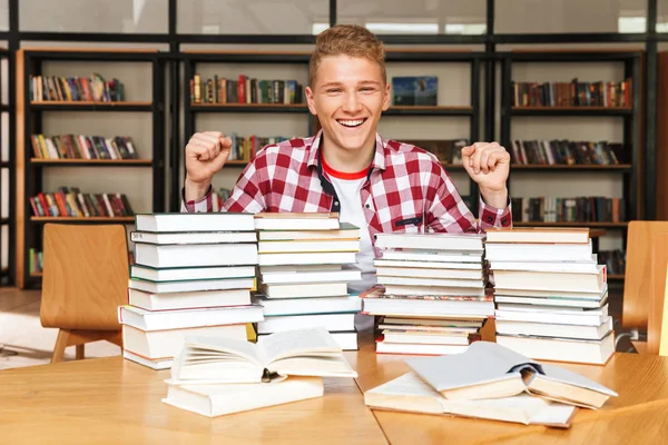 Opgewonden Tiener Zitten Aan Tafel Van Bibliotheek Met Grote Stapels — Stockfoto