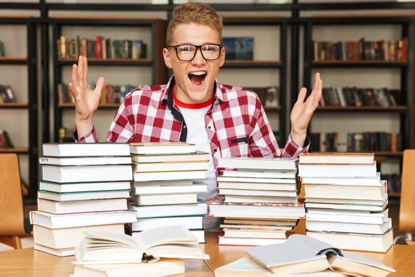 Возбужденный Подросток Сидит Библиотечным Столом Большими Стопками Книг — стоковое фото