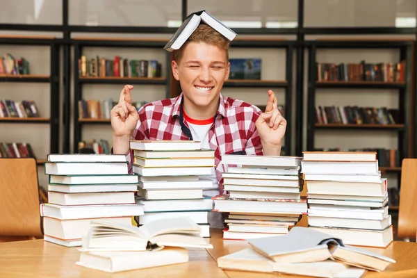 Χαμογελαστά Εφηβικό Αγόρι Κάθεται Στο Τραπέζι Βιβλιοθήκη Μεγάλες Στοίβες Βιβλίων — Φωτογραφία Αρχείου