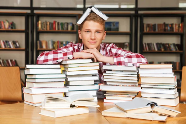 Улыбающийся Подросток Сидящий Библиотечным Столом Большими Стопками Книг — стоковое фото