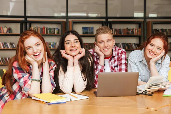 Grupo Adolescentes Sorridentes Fazendo Lição Casa Enquanto Sentados Biblioteca Com — Fotografia de Stock