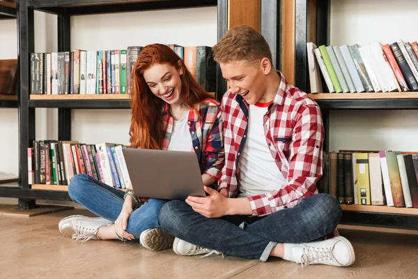 Sorridente Coppia Adolescenti Seduti Pavimento Presso Libreria Una Biblioteca Utilizzando — Foto Stock