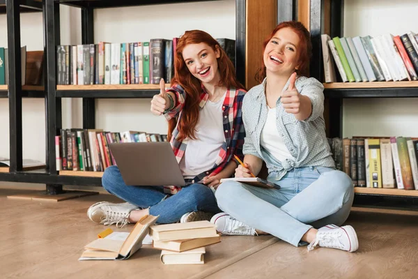 Duas Meninas Adolescentes Amigáveis Sentadas Chão Estante Livros Uma Biblioteca — Fotografia de Stock