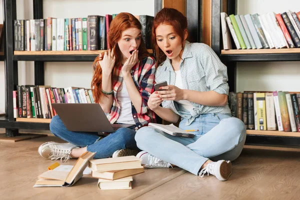 Deux Adolescentes Choquées Assises Sur Sol Bibliothèque Faisant Leurs Devoirs — Photo