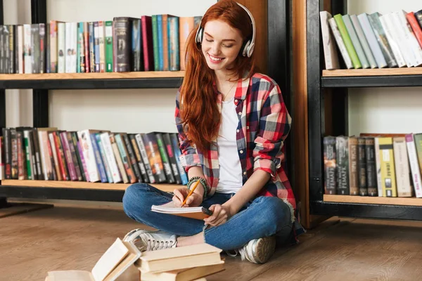 Prachtige Tienermeisje Huiswerk Terwijl Zittend Bibliotheek Luisteren Naar Muziek Met — Stockfoto