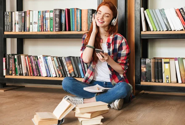 Schattige Tienermeisje Huiswerk Terwijl Zittend Bibliotheek Het Luisteren Naar Muziek — Stockfoto
