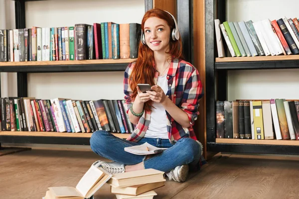 Gelukkig Tienermeisje Huiswerk Terwijl Zittend Bibliotheek Het Luisteren Naar Muziek — Stockfoto