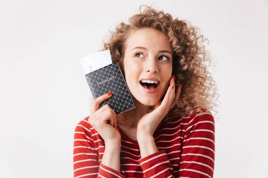 Kıvırcık saçlı beyaz arka plan üzerinde izole pasaport tutan genç kız mutlu portre kadar kapatın