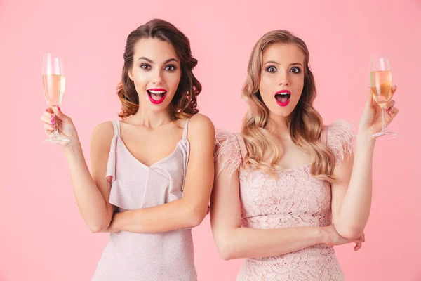 Two Surprised Elegant Women Dresses Drinking Champagne Looking Camera Pink — Stock Photo, Image