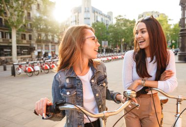 İki genç güzel kadın arkadaşlar açık havada Bisiklet Park ile görüntü.