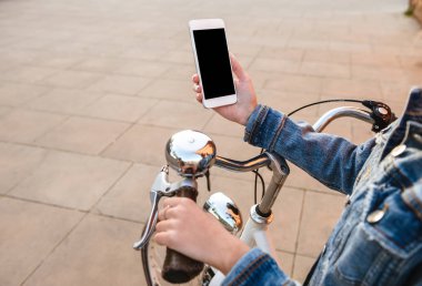 Cep telefonu kullaranarak Caddesi üzerinde açık havada bisikletle genç bayan resim kırpılmış. Boş siyah ekran.