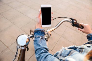Cep telefonu kullaranarak Caddesi üzerinde açık havada bisikletle genç bayan resim kırpılmış. Boş siyah ekran.