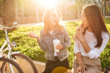İki genç güzel kadın arkadaşlar açık havada Bisiklet Park ile görüntü.