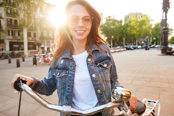 屋外カメラを探して路上自転車の若い美しい女性の写真 — ストック写真